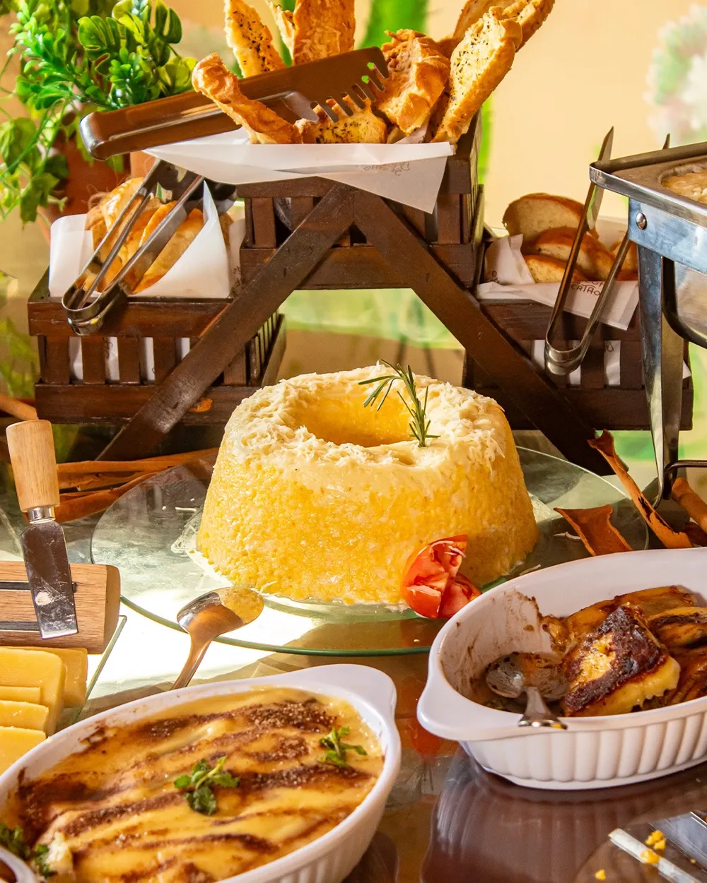 Mesa com cuscuz, pães e gratinados