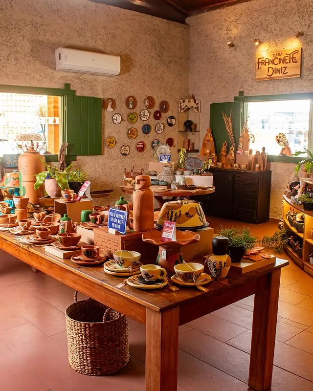 Salão da lojinha com mesas de artesanato